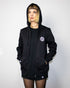 "Harmony" Zip Hoodie in schwarz, getragen von einem weiblichen Model, fotografiert von vorne.